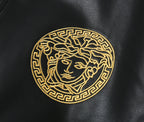 Black leather bomber jacket close-up of gold medallion emblem on the chest