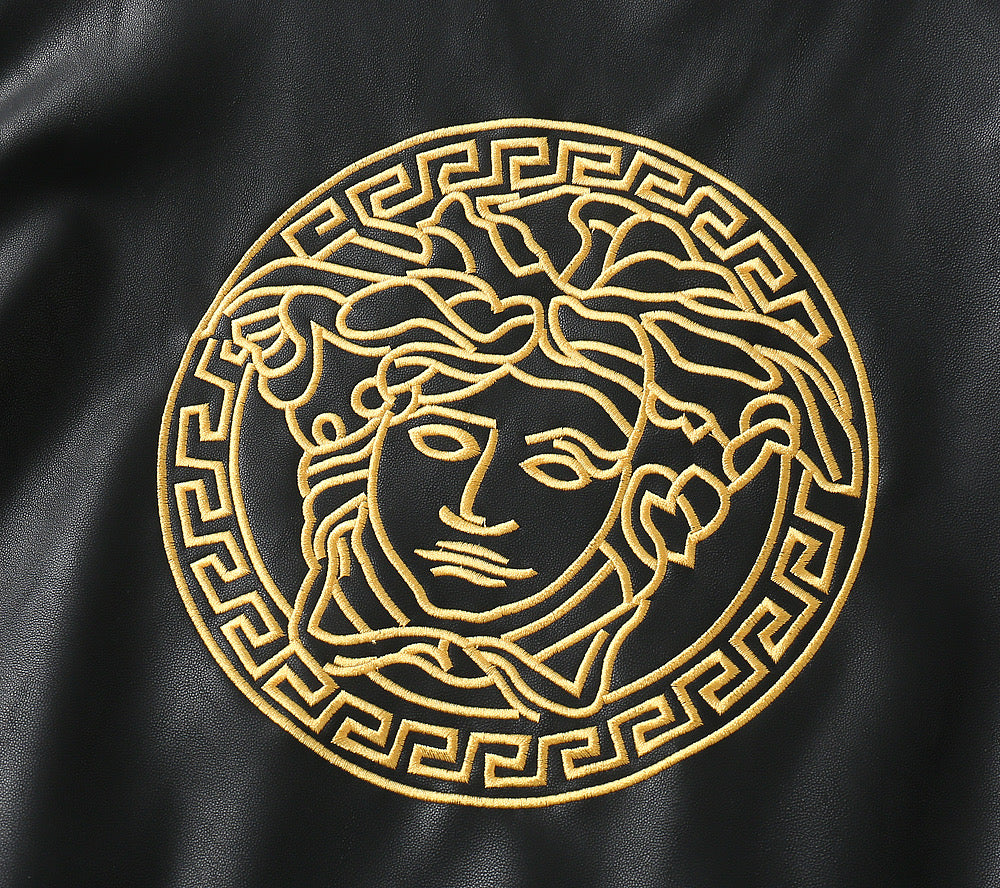 Gold Medusa-style emblem on black leather jacket front