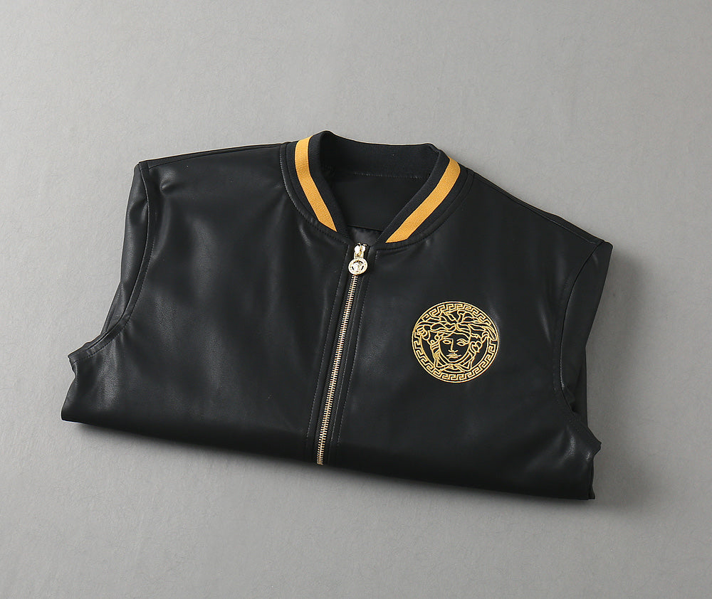Black leather bomber jacket, flat lay, with gold medallion logo and ribbed trim collar