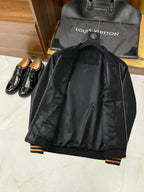 Black leather bomber jacket with ribbed striped cuffs and visible back panel stitching