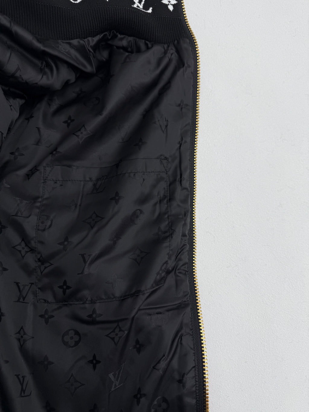 Black Louis Vuitton satin lining with monogram pattern and gold zipper