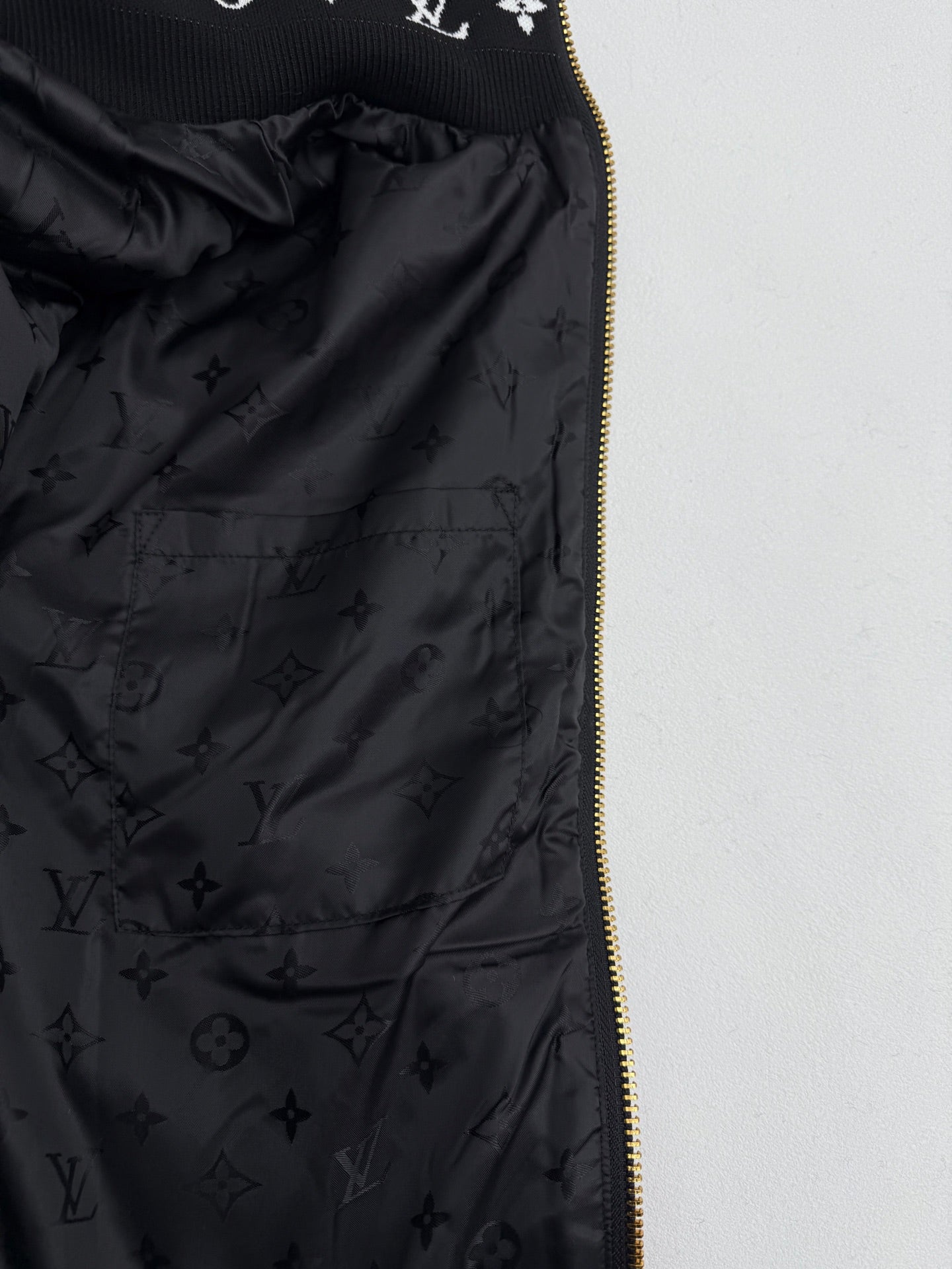 Black Louis Vuitton satin lining with monogram pattern and gold zipper