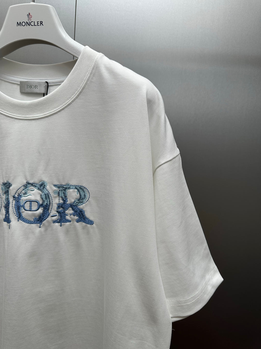 White short-sleeve crewneck T-shirt with blue Dior logo graphic on chest