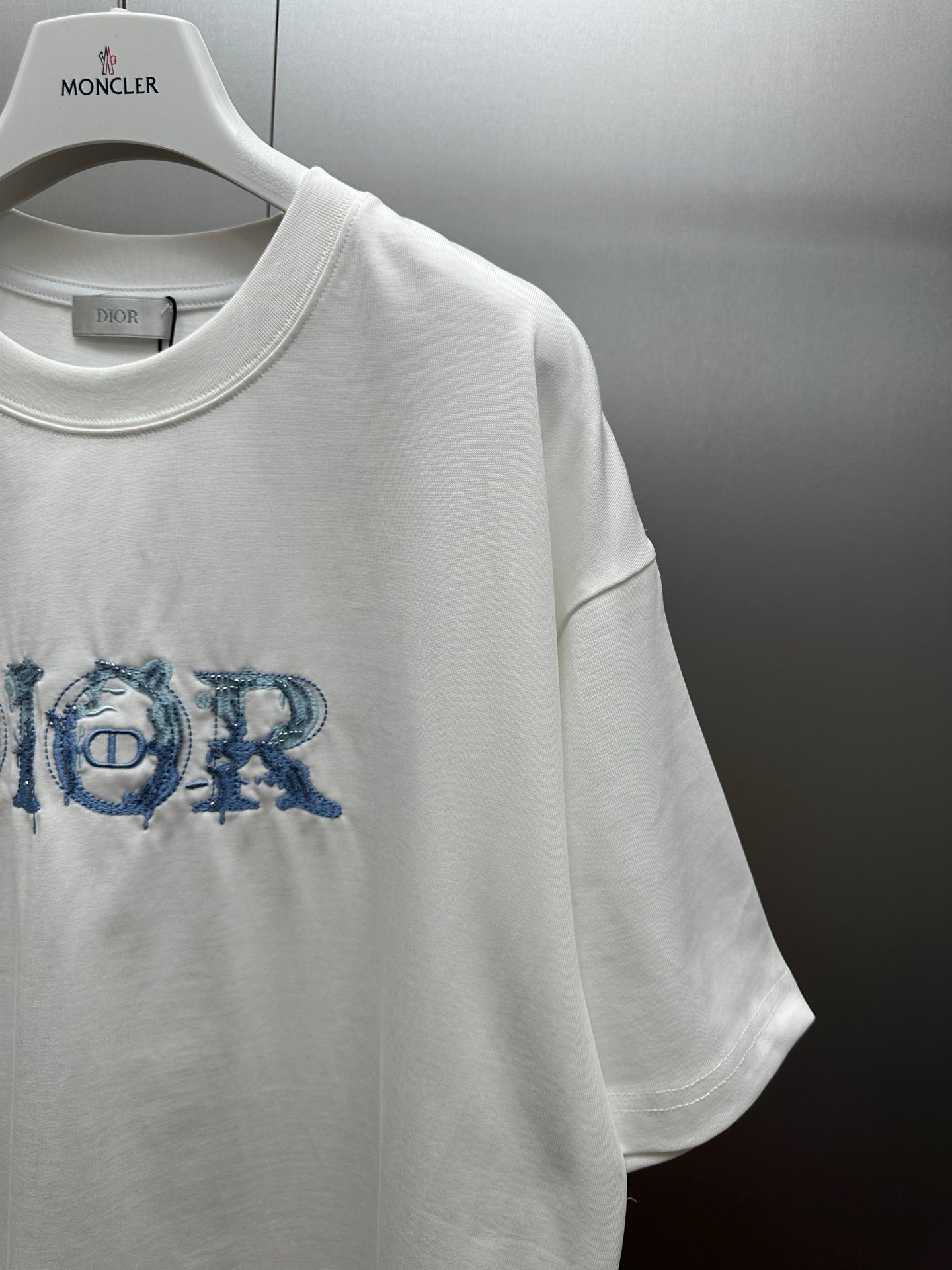 White short-sleeve crewneck T-shirt with blue Dior logo graphic on chest