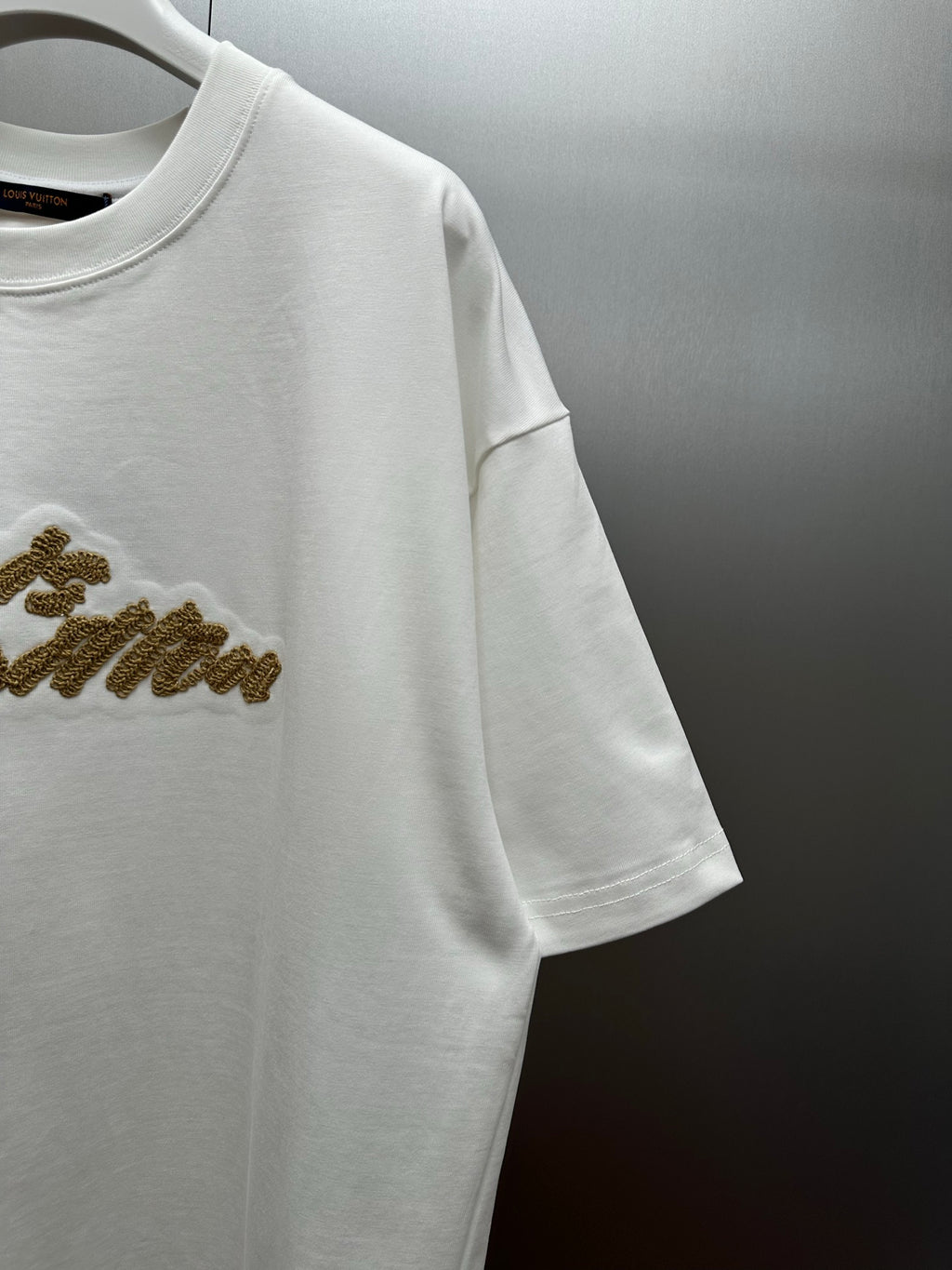Louis Vuitton white short-sleeve shirt with gold logo detail on sleeve
