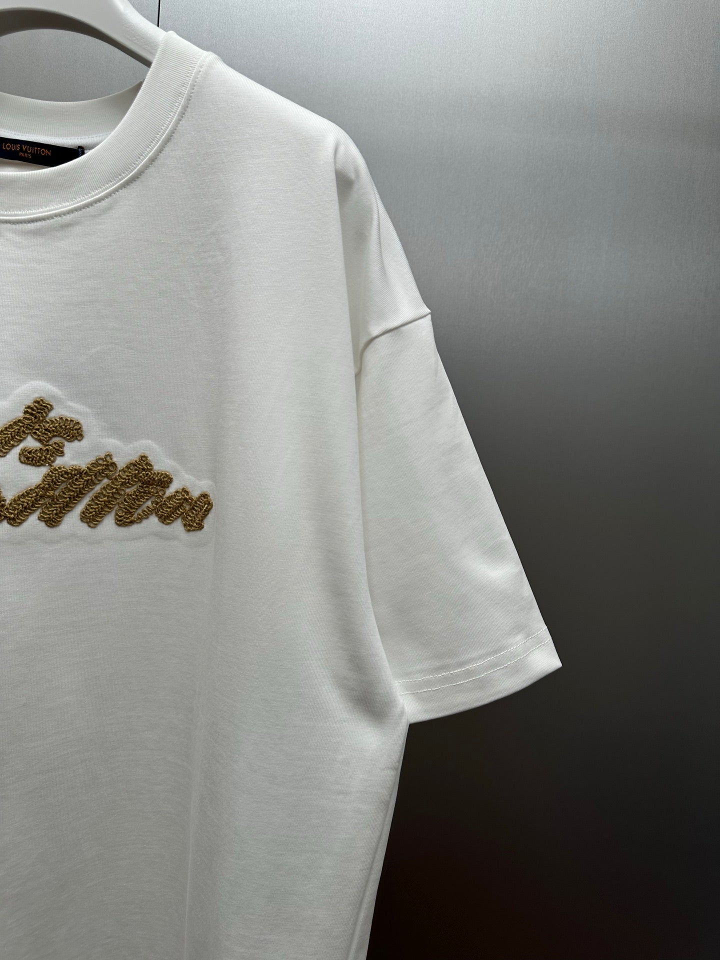 Louis Vuitton white short-sleeve shirt with gold logo detail on sleeve