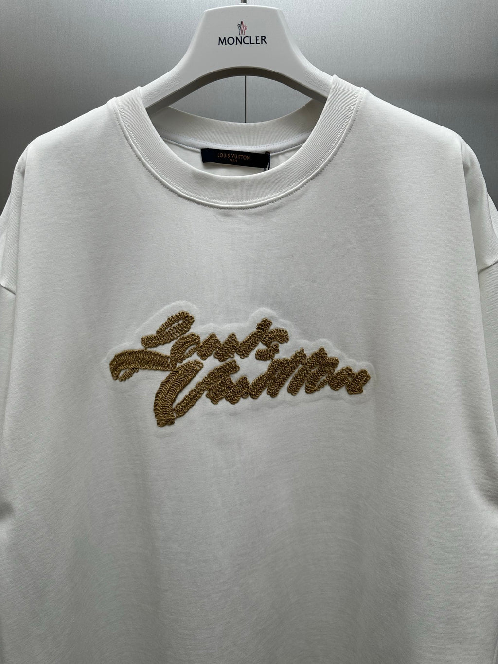 Louis Vuitton white short-sleeve shirt with gold embroidered script on chest