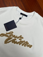 Louis Vuitton white short-sleeve shirt with gold embroidered script and navy hang tag