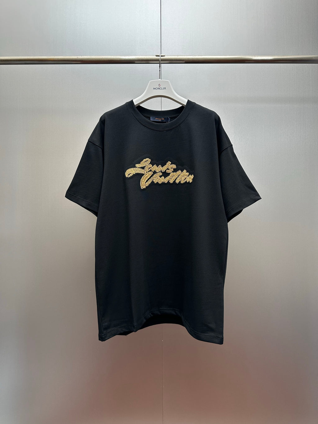 Louis Vuitton black short-sleeve T-shirt with gold script logo on the chest