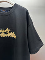 Louis Vuitton black T-shirt with gold embroidered script logo detail, short sleeve close-up