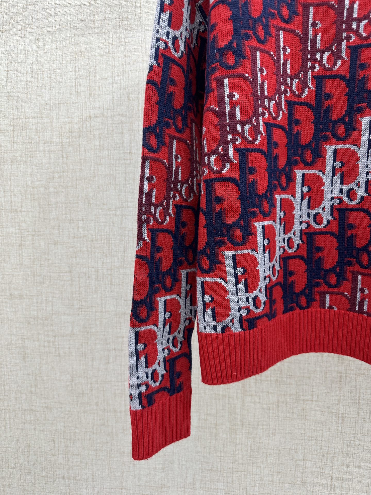 Dior knit sweater sleeve and hem, red and navy logo pattern with ribbed cuff