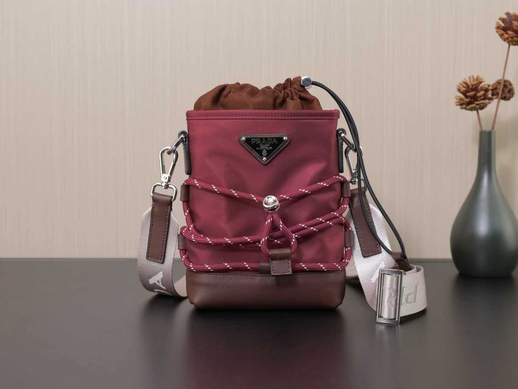 Prada mini bag in burgundy with triangular logo, drawstring top and crossbody strap