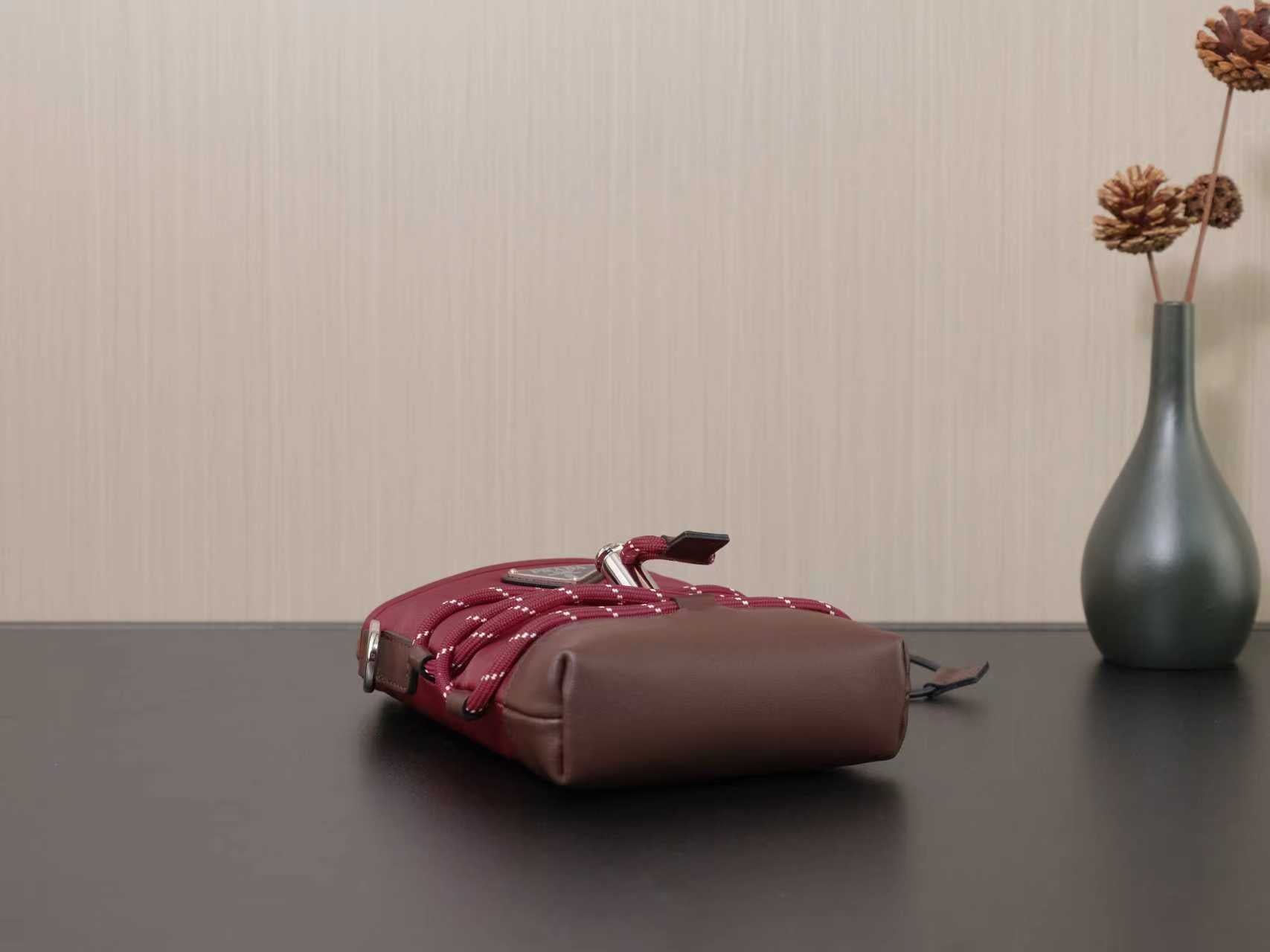 Burgundy and brown mini bag with bow-tie detail, handles, and silver feet