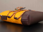Yellow and brown Prada bag with braided strap and rounded brown side panel.