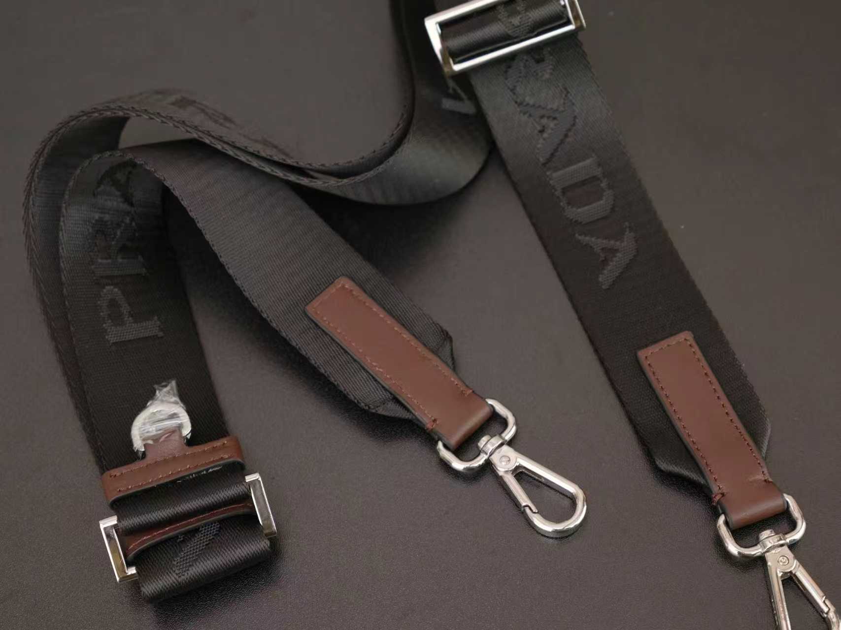 Brown leather and black webbing bag strap set with metal buckles.