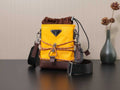 Yellow Prada bag with brown drawstring top and metal logo plaque.