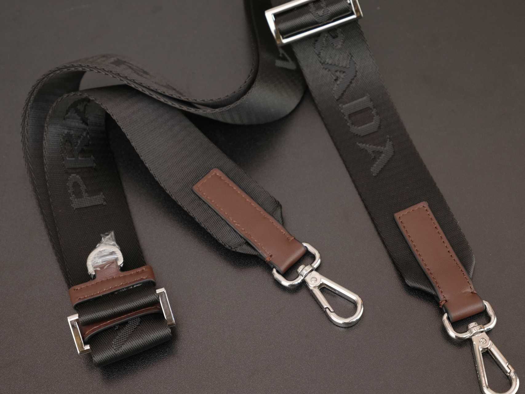 Prada bag strap set with brown leather tabs and silver metal hardware, detail view