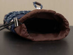 Prada bag interior view with open top and dark lining, showing silver hardware post