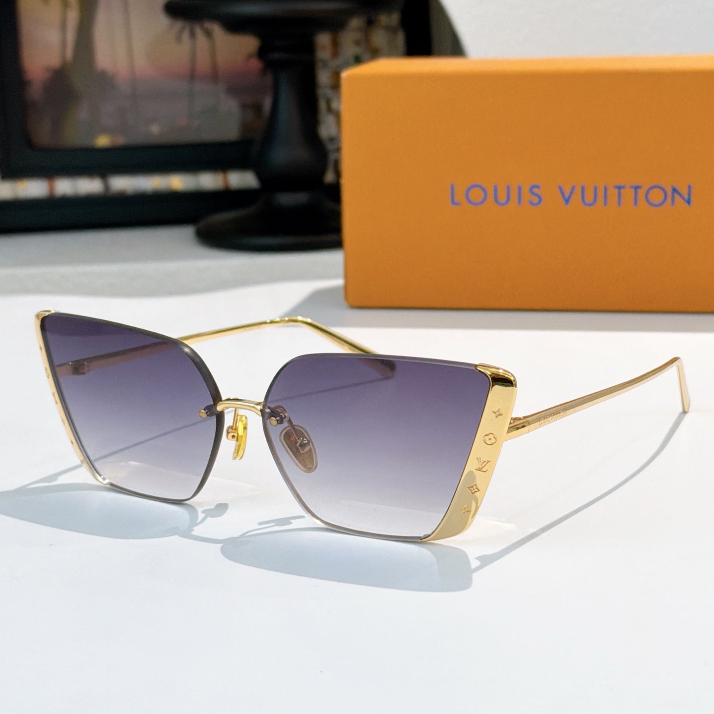 Gold-tone Louis Vuitton sunglasses with gradient blue-violet lenses and cat-eye frames