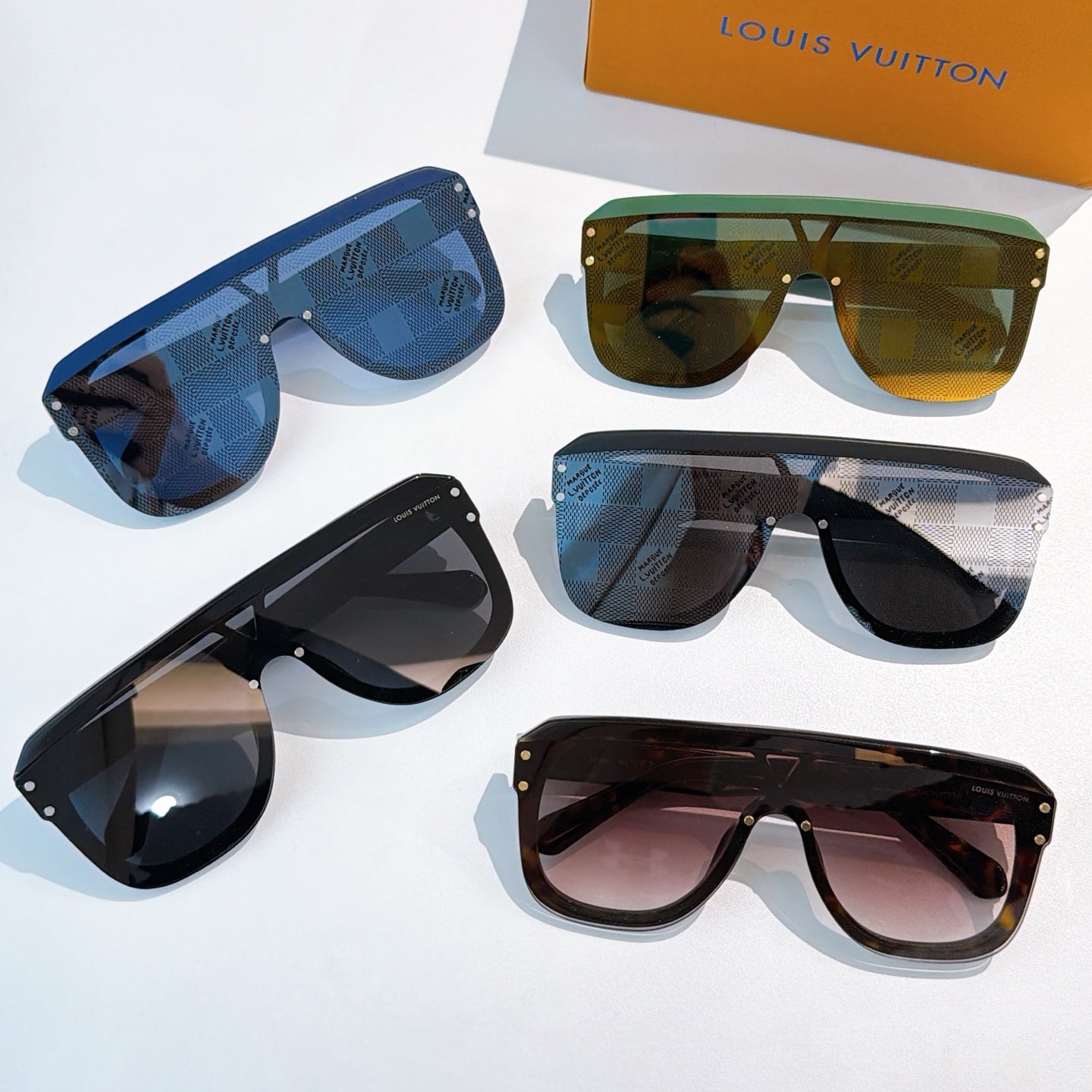Assorted sunglasses with blue, green, black, and pink tinted lenses
