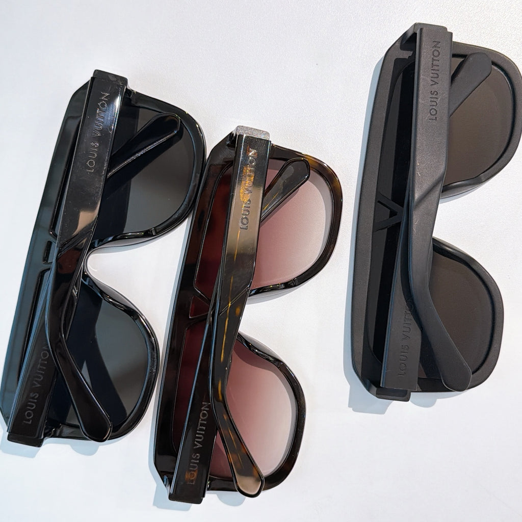 Assorted black and tortoiseshell sunglasses with tinted lenses and cases