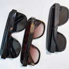 Assorted black and tortoiseshell sunglasses with tinted lenses and cases