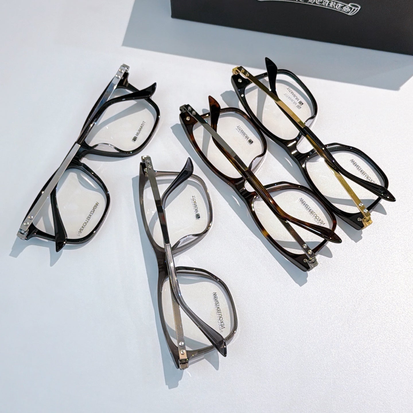 Set of mixed-color eyeglasses with clear lenses on display.