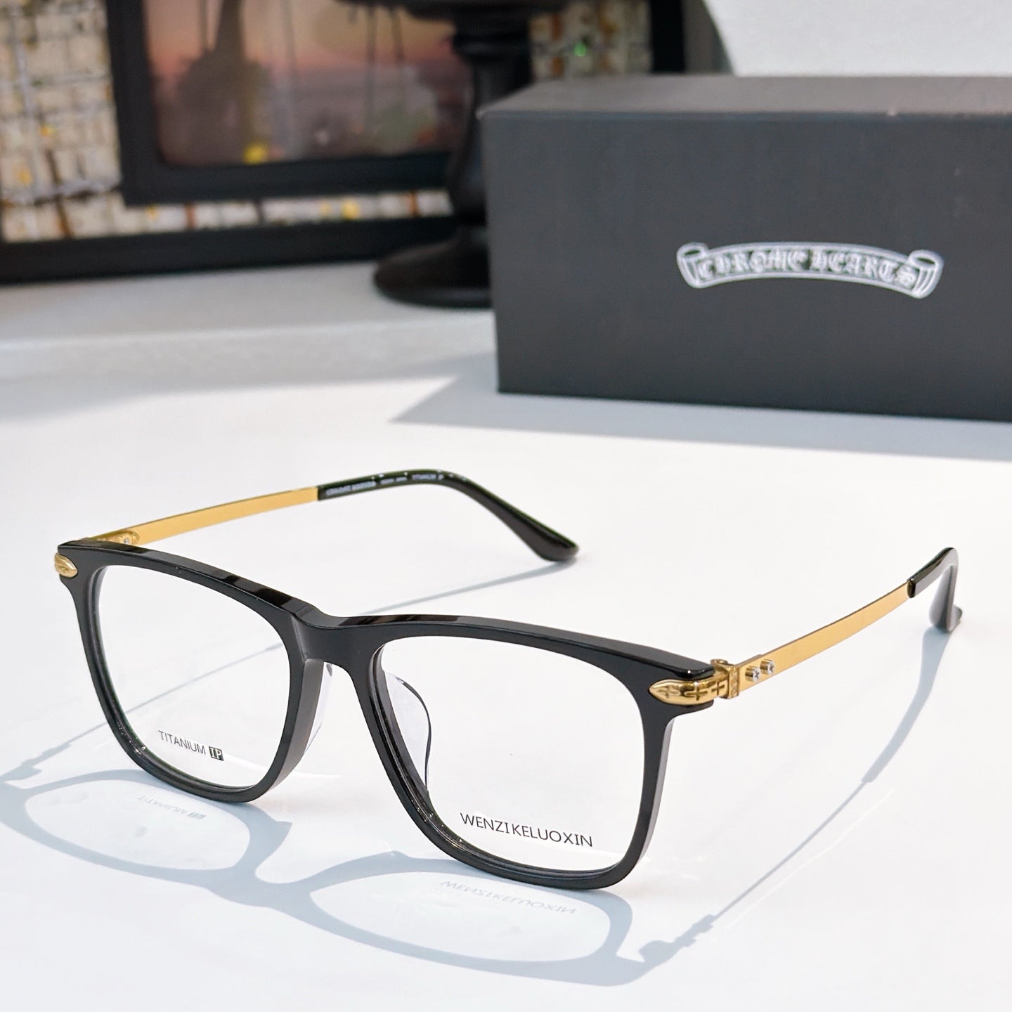 Black and gold eyeglasses with clear lenses, rectangular frames.
