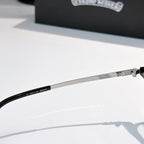 Metal eyeglass arm with markings and clear lens frame, side view.