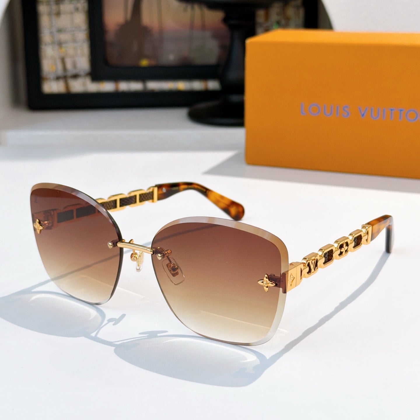 Designer sunglasses with brown gradient lenses and gold link temples