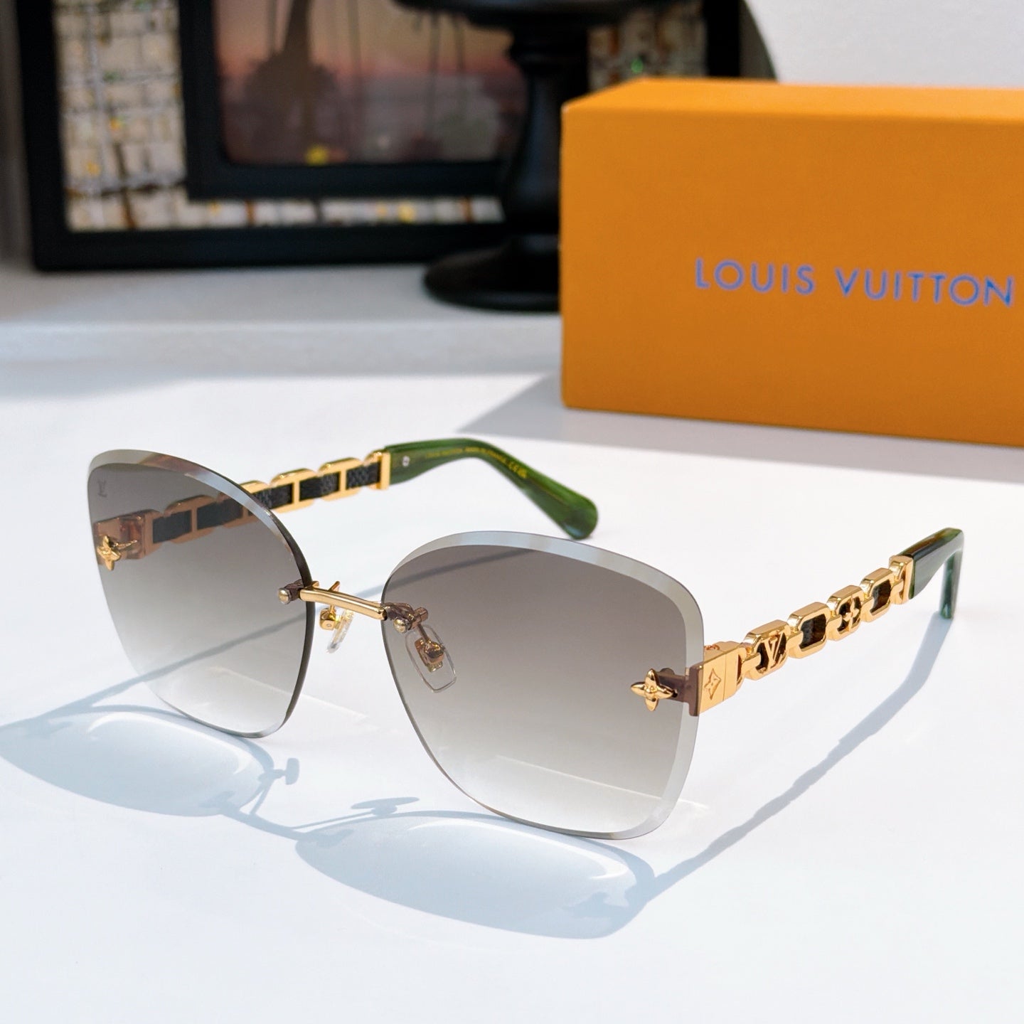 Designer sunglasses with taupe gradient lenses and gold link temples