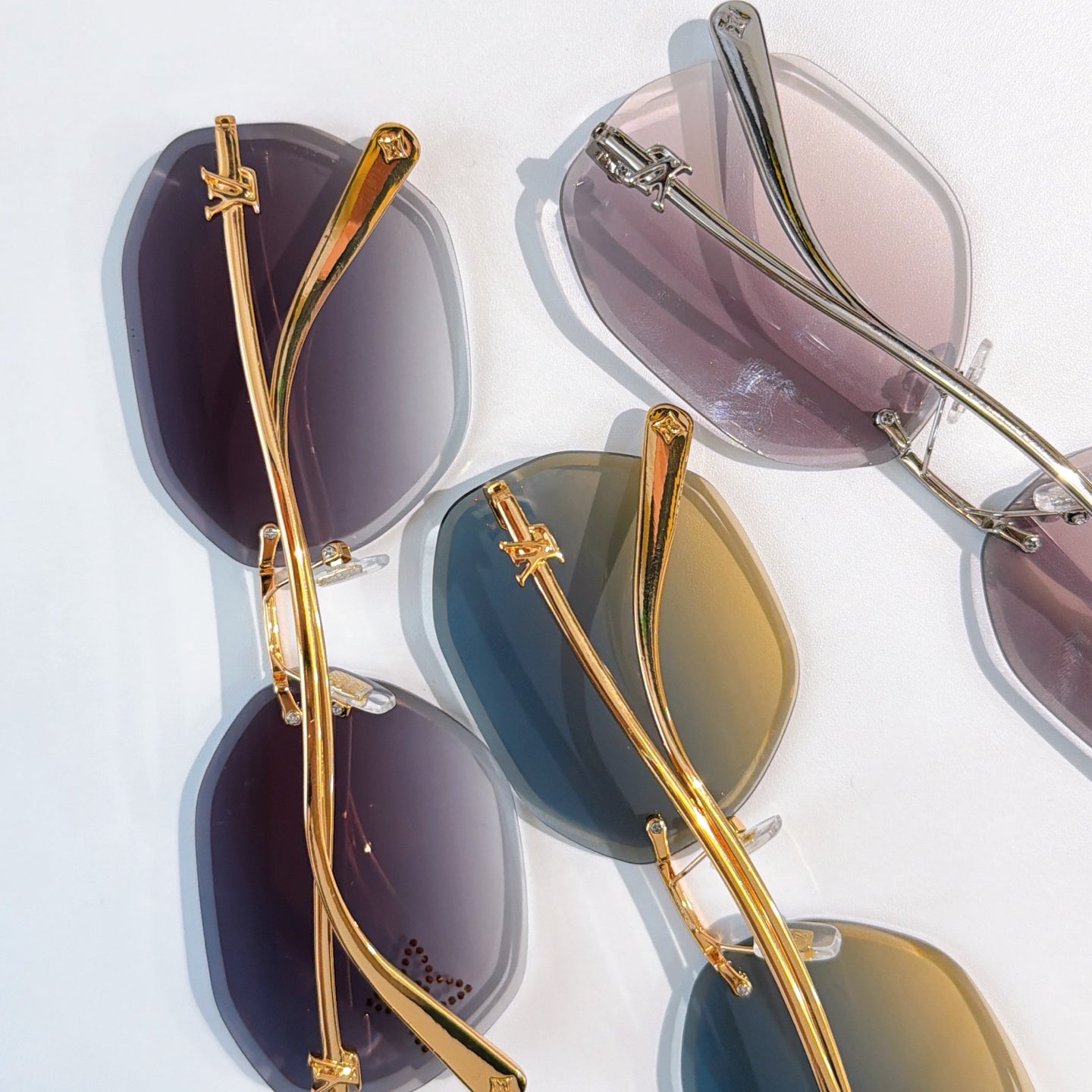 Louis Vuitton gold-rimmed sunglasses with dark lenses, assorted frames shown