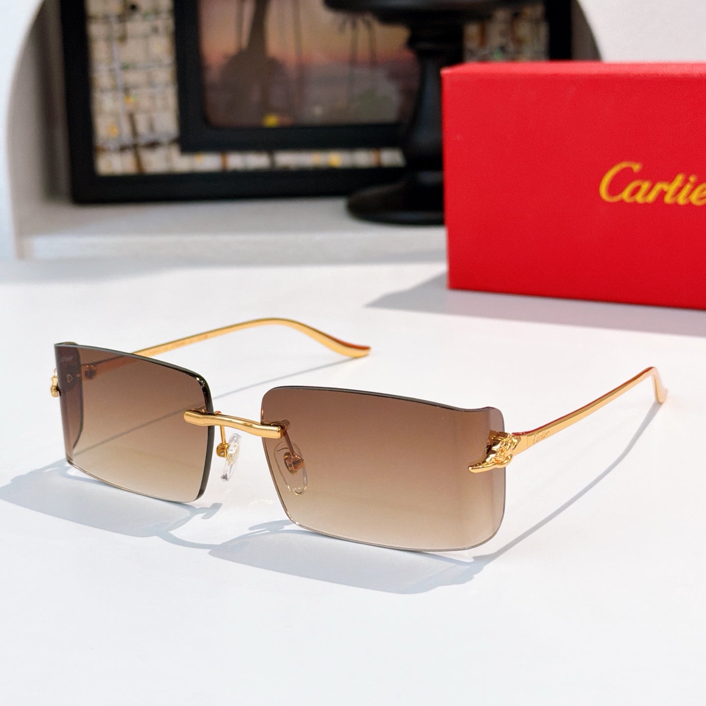 Cartier sunglasses with brown gradient lenses, gold metal frame, rectangular