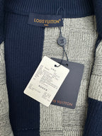 Close-up of knit collar and label on navy-and-gray patchwork zip sweater