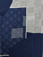 Patchwork detail of navy knit jacket with textured logo panel and gray checkered section