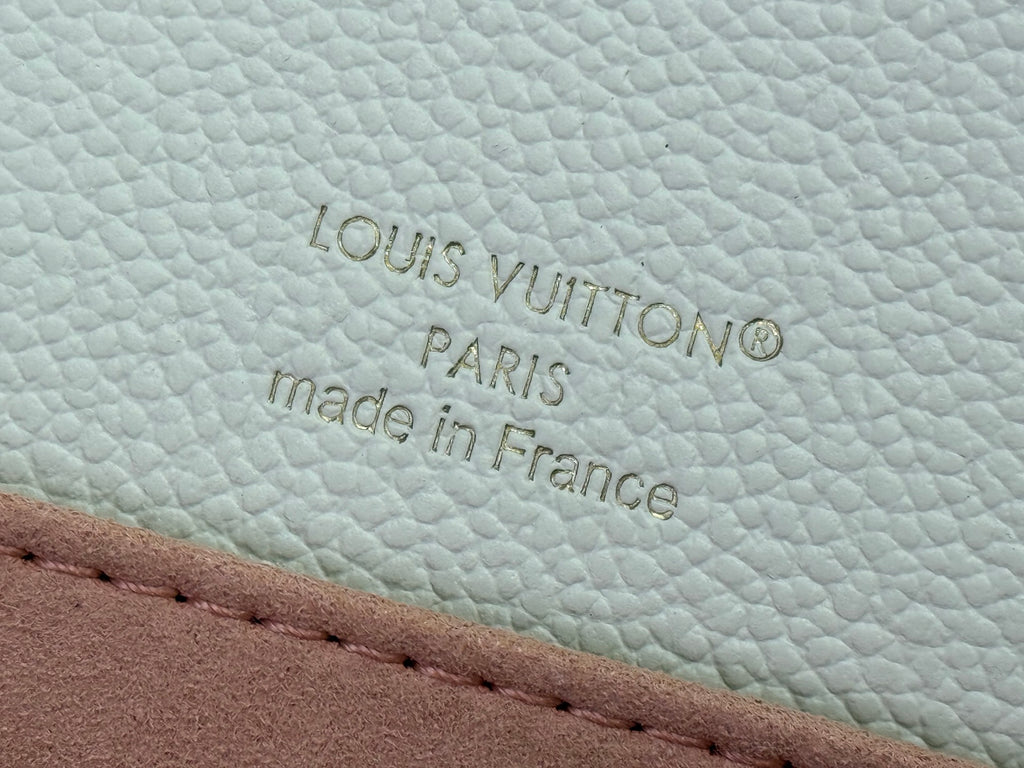 Louis Vuitton embossing and “made in France” on cream leather with stitched trim