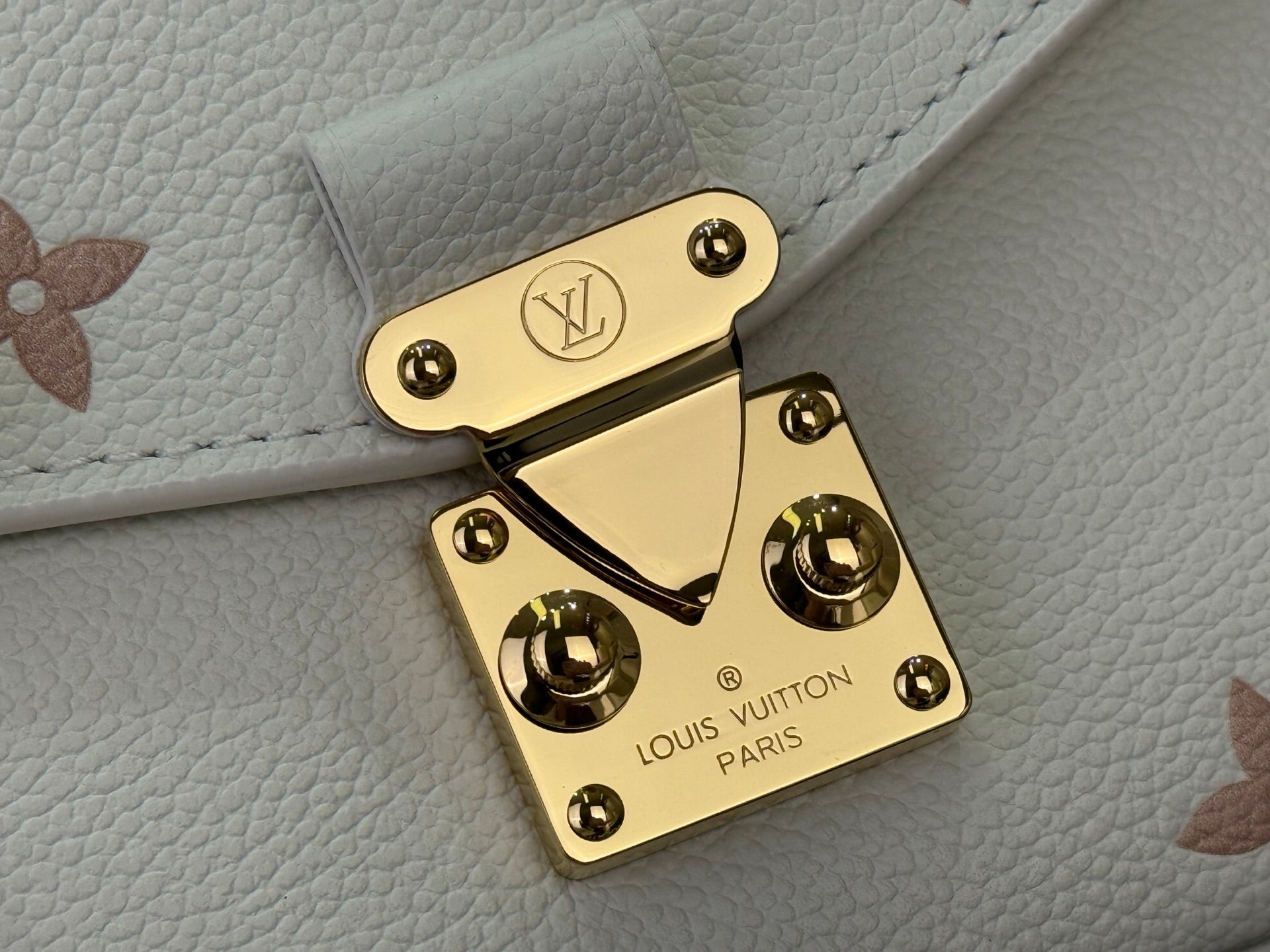 Louis Vuitton logo gold-tone turn-lock on cream leather bag flap with studs