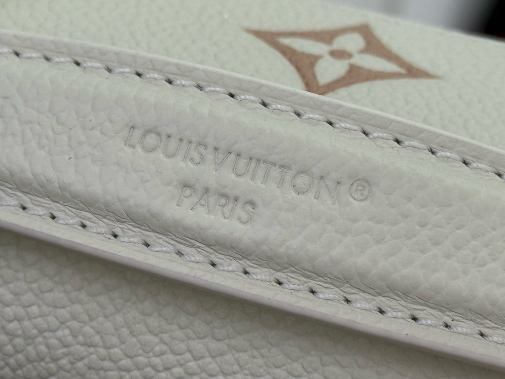 Louis Vuitton embossed monogram on cream leather edge with stitched detailing