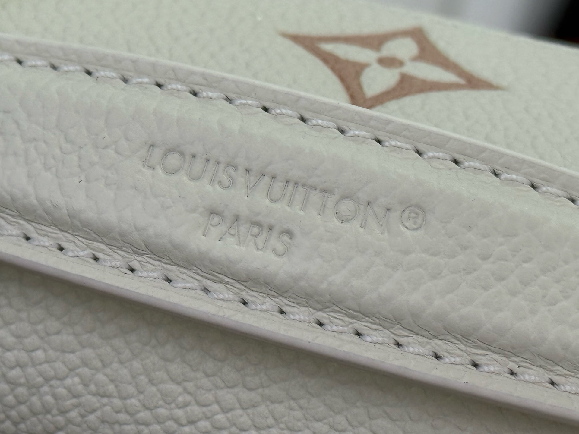 Louis Vuitton embossed monogram on cream leather edge with stitched detailing