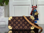 Monogram tote with tan crossbody strap and gold corner feet, front angled view