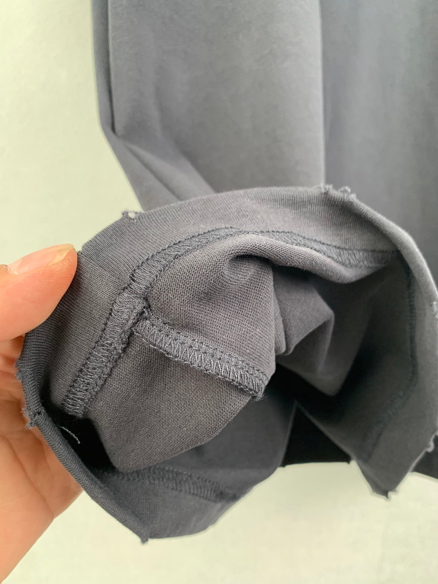 Balenciaga T-shirt sleeve cuff and seam close-up with hand