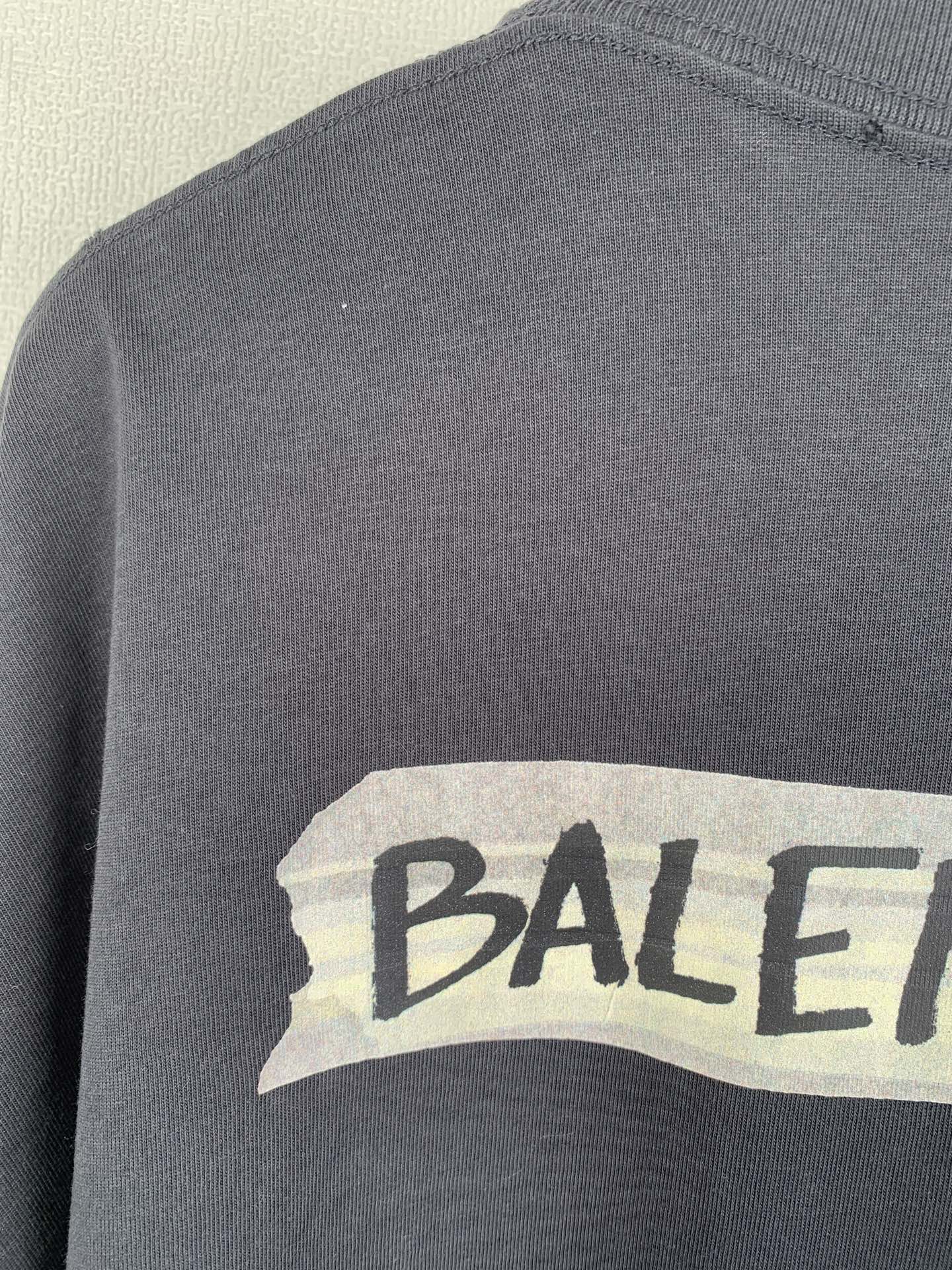 Dark short-sleeve top with BALENCIAGA logo print on chest