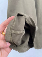 Balenciaga T-shirt sleeve hem and cuff seam in olive, fabric fold close-up