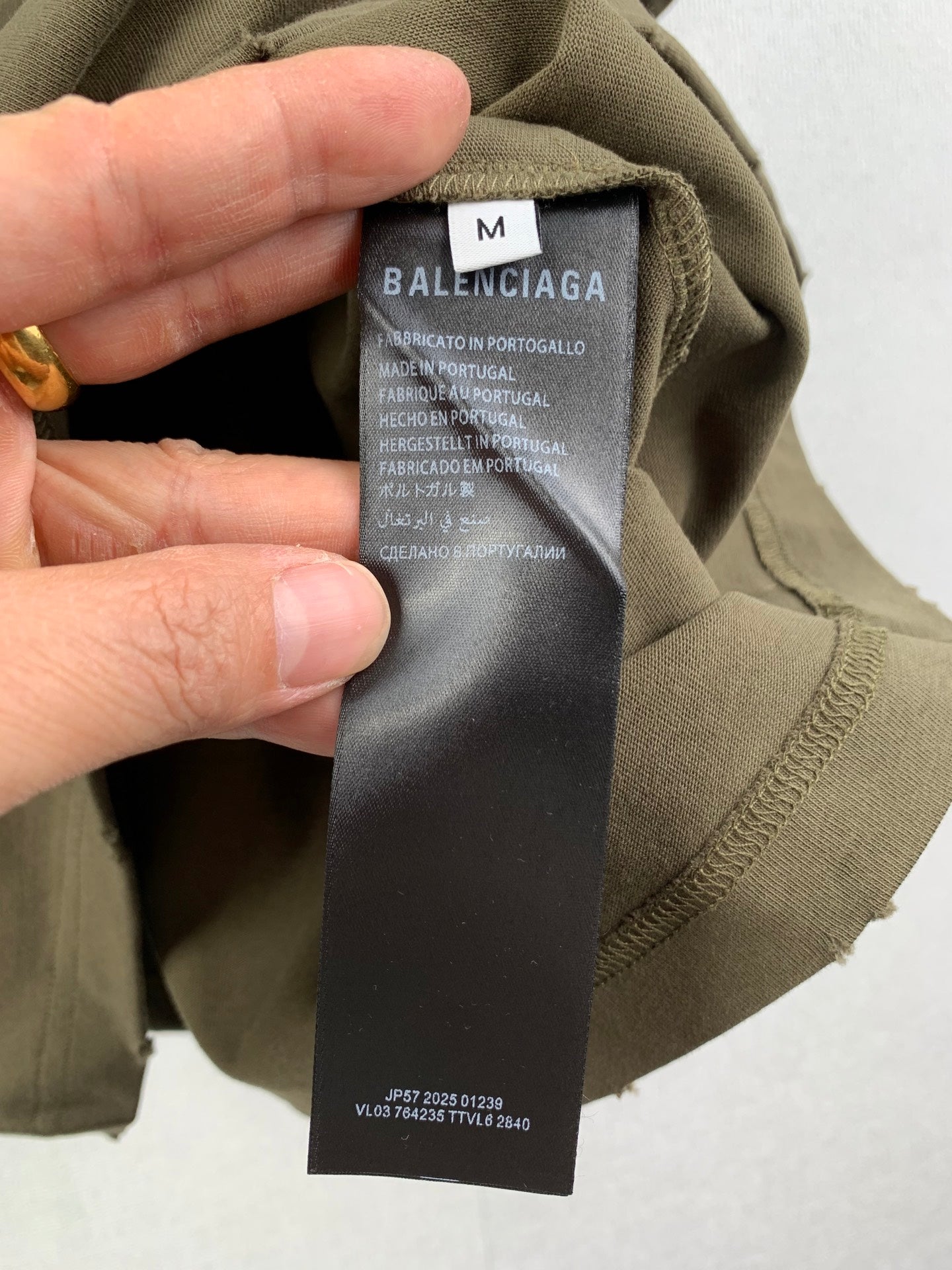 Olive green shorts with interior fabric tag and Balenciaga logo label