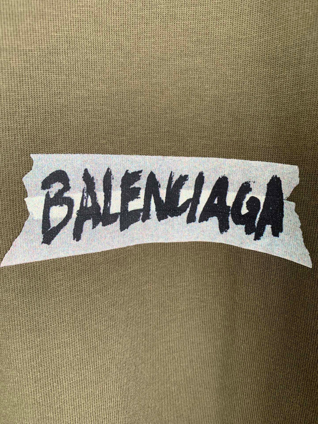 Balenciaga logo print on olive T-shirt chest area, white backing with black text