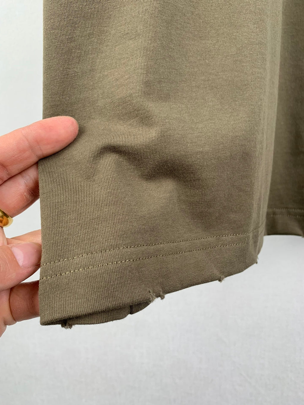 Balenciaga T-shirt hem in olive with stitched bottom edge and slight fabric wrinkle