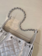 Chanel quilted chain-strap shoulder bag in silver tone, close-up of chain handles and eyelets