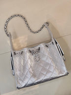 Chanel quilted chain-strap shoulder bag in silver tone, side view with metal tassel pulls