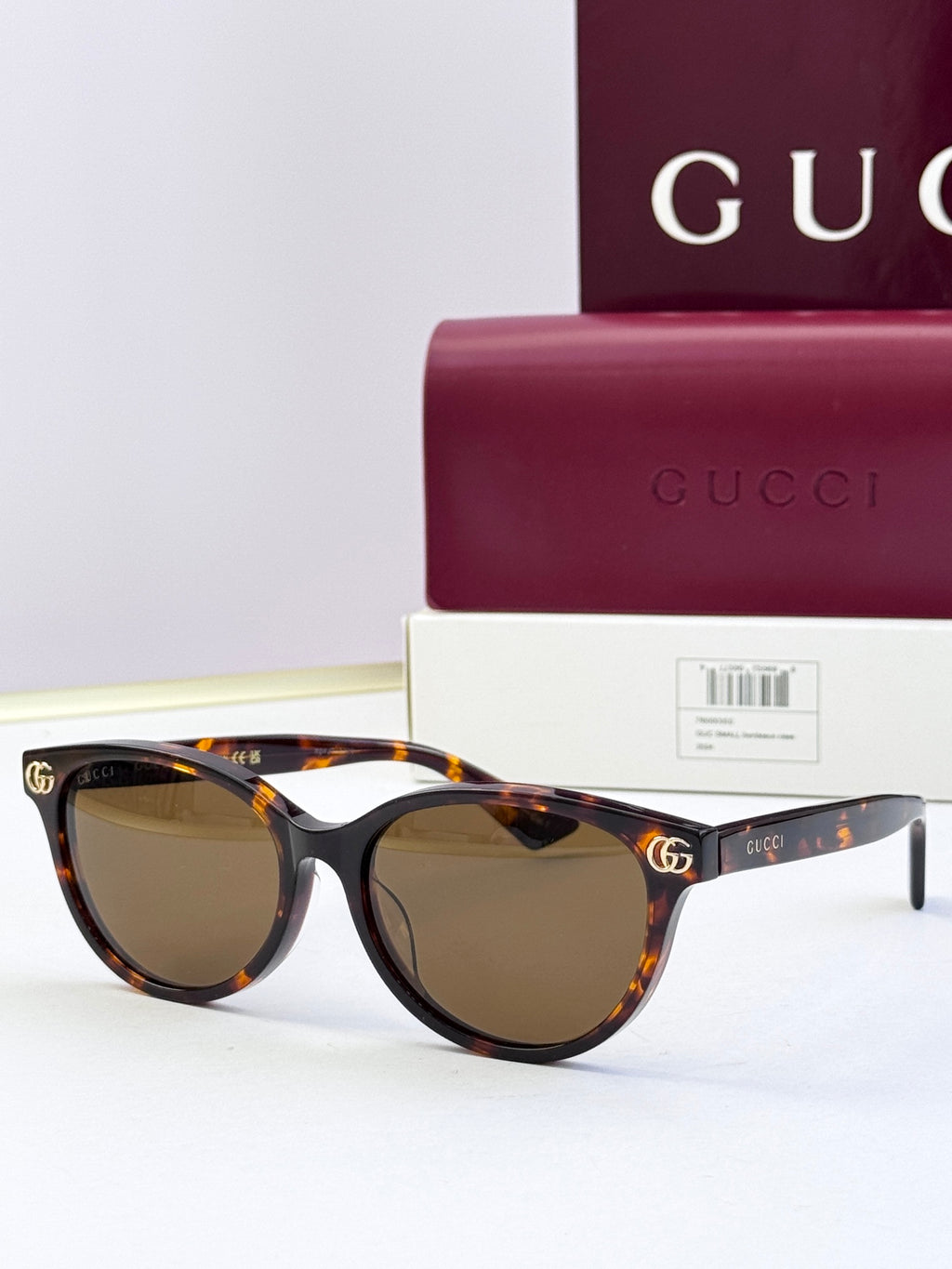 Tortoiseshell eyeglass frames with brown lenses and gold logo detail at temples