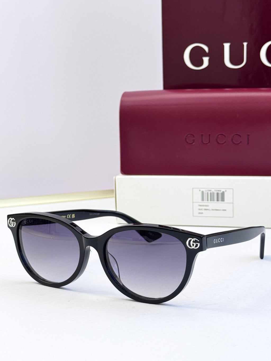 Black eyeglass frames with tinted lenses and gold logo detail at temples